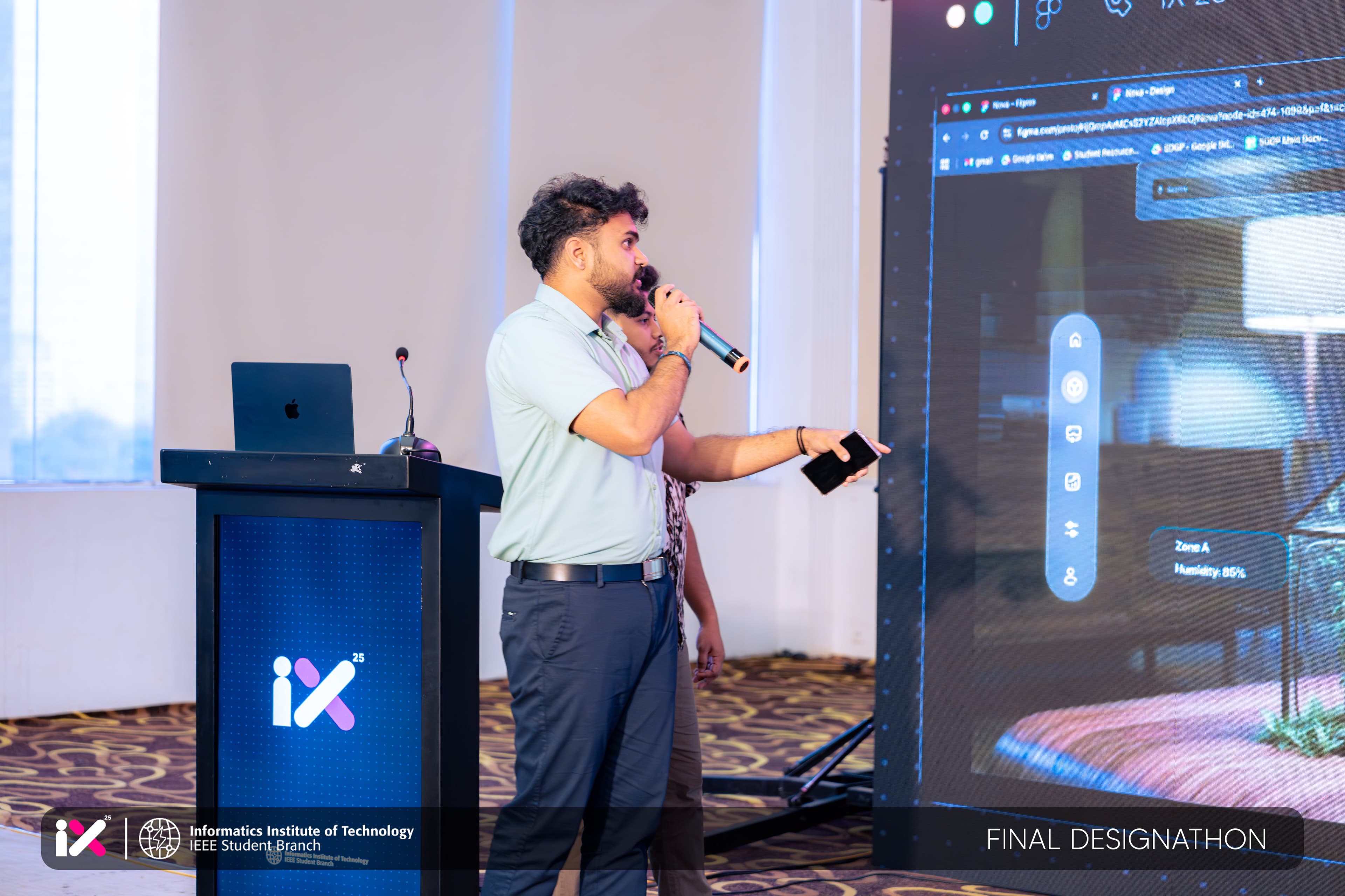 A team demoing a Figma prototype on the main screen at IX 25